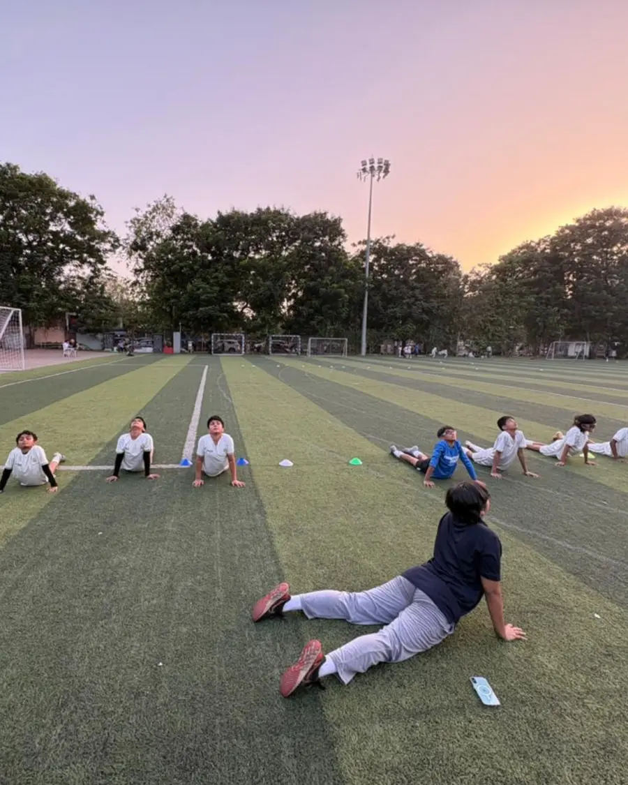 Young footballers warming up at sunset