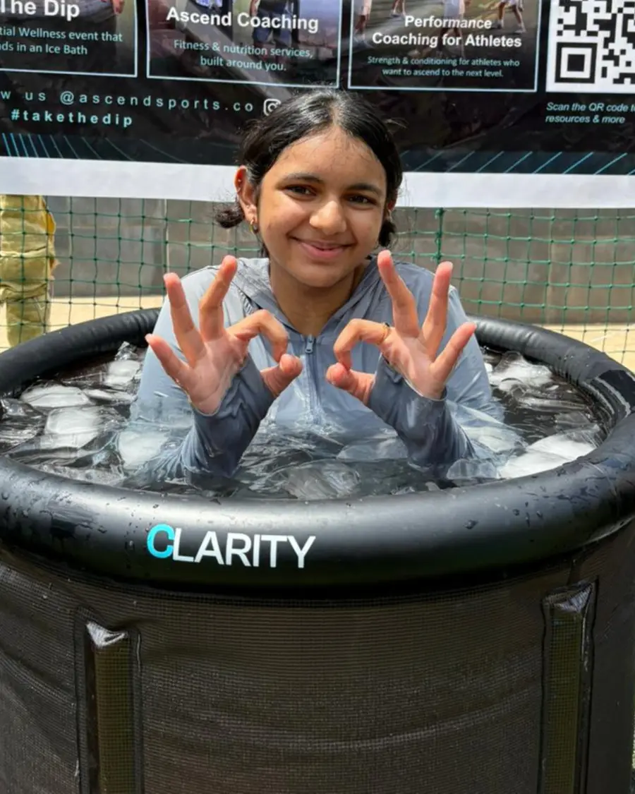 A young participant smiling in an ice bath