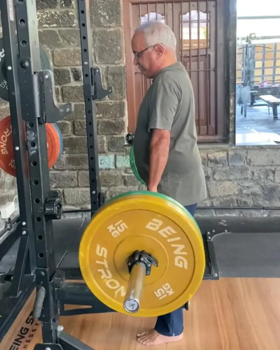 An older client deadlifting