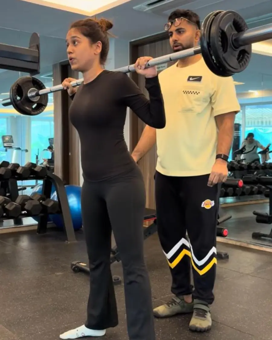 Amogh guiding a client through a barbell squat